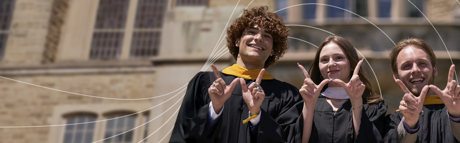 Graduated students making a "W" with their hands
